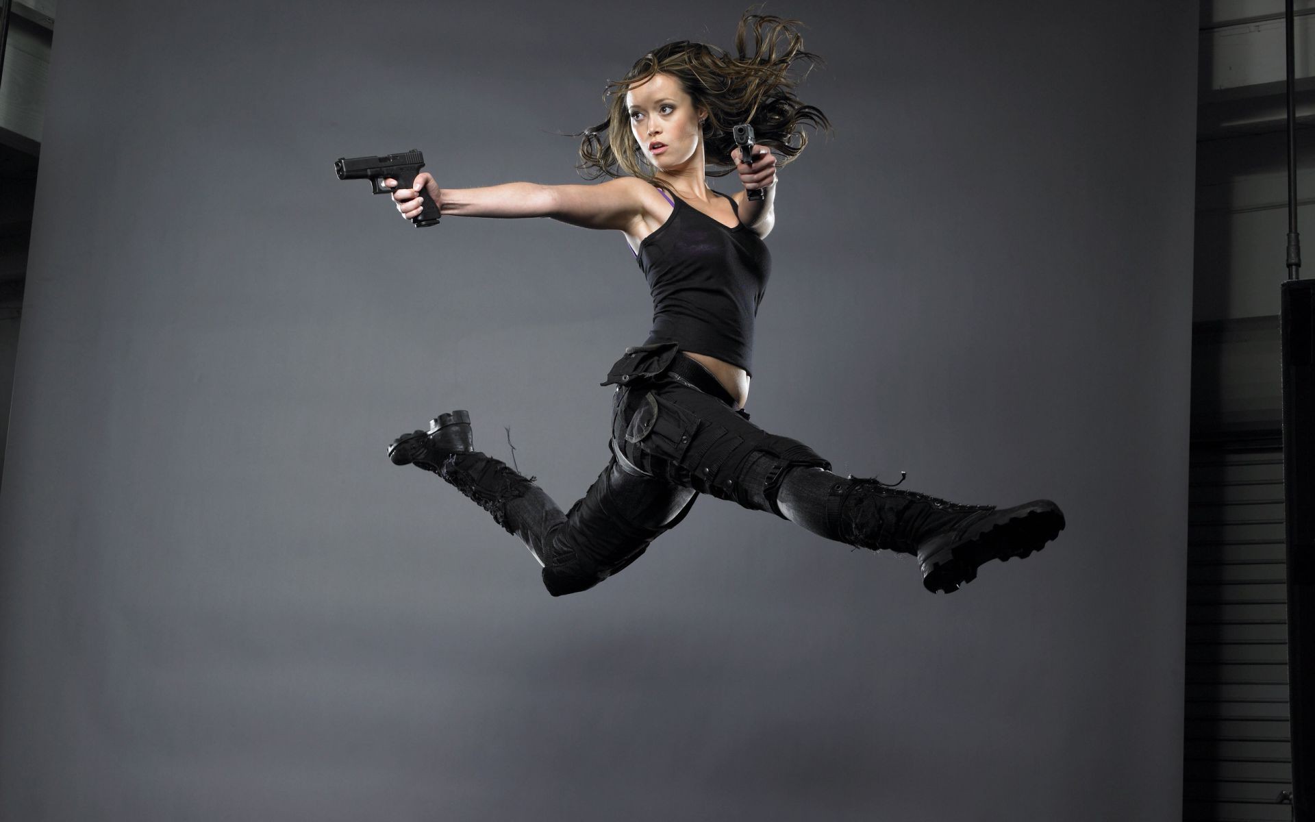 Девушка в прыжке с пистолетами