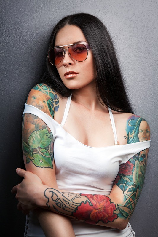Брюнетка в очках, татуировки на руках