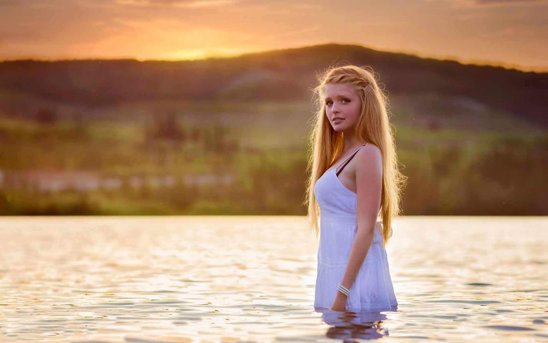Девушка стоит в воде, закат