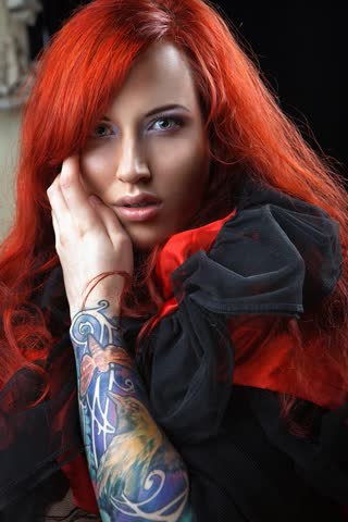 Рыжеволосая девушка с татуировкой на руке