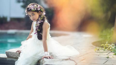 Девочка с цветами в волосах, белое платье