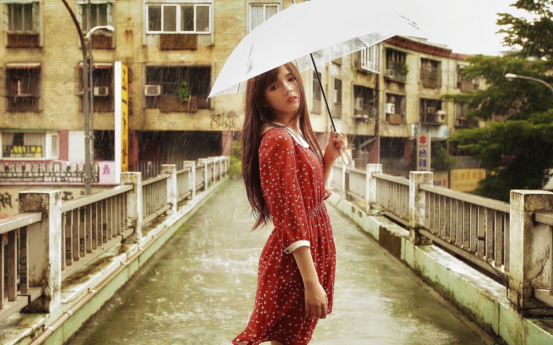 Азиатка с зонтом под дождём